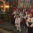 Îmbrăcaţi în costume naţionale, copiii cântă în corul bisericii păstorite de preoţii Saftiuc, tată şi fiu