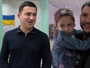 Mihai şi Dumitru împreună cu un copil refugiat